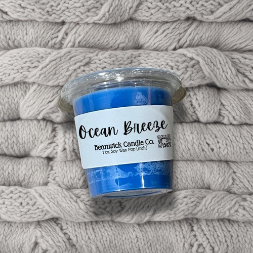 a blue candle sitting on top of a pile of blankets