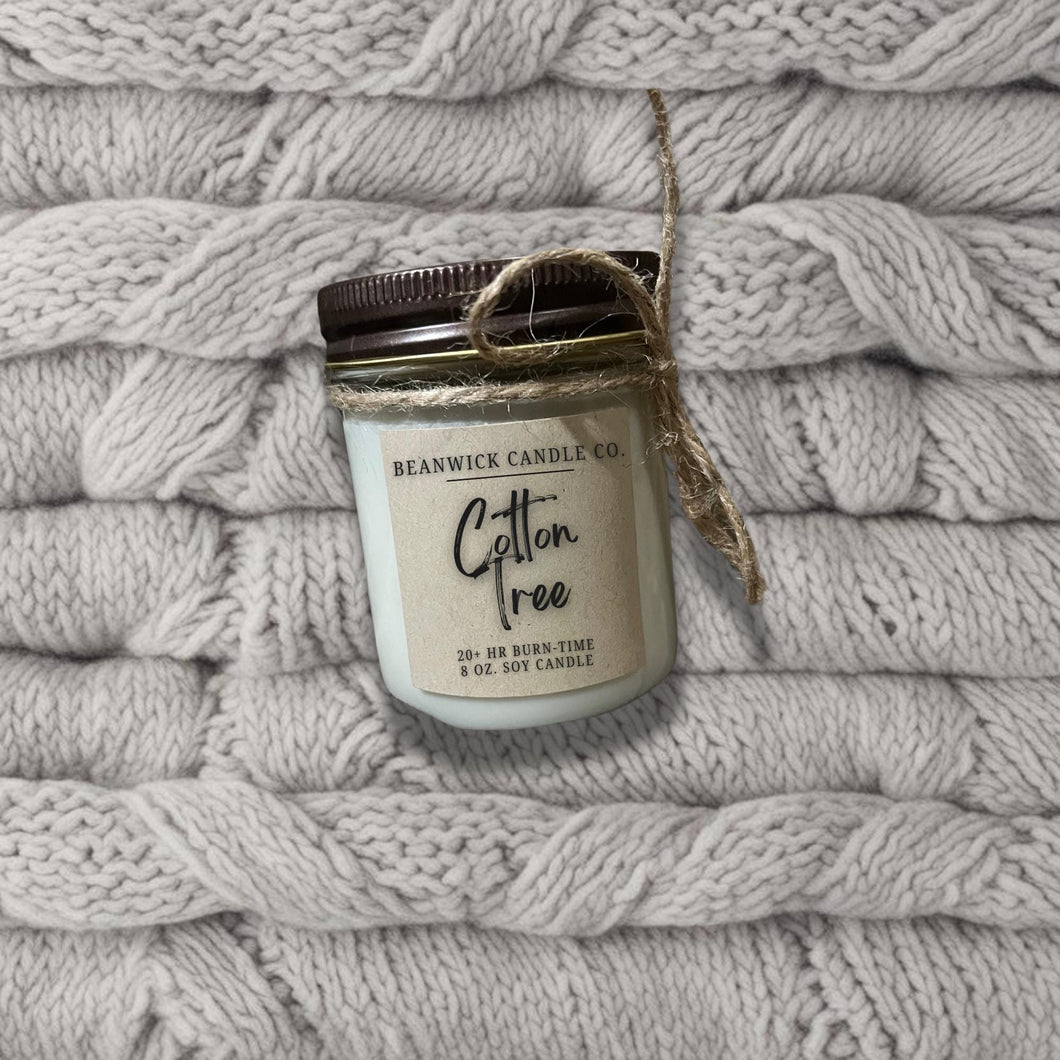 a jar of cotton sitting on top of a pile of blankets