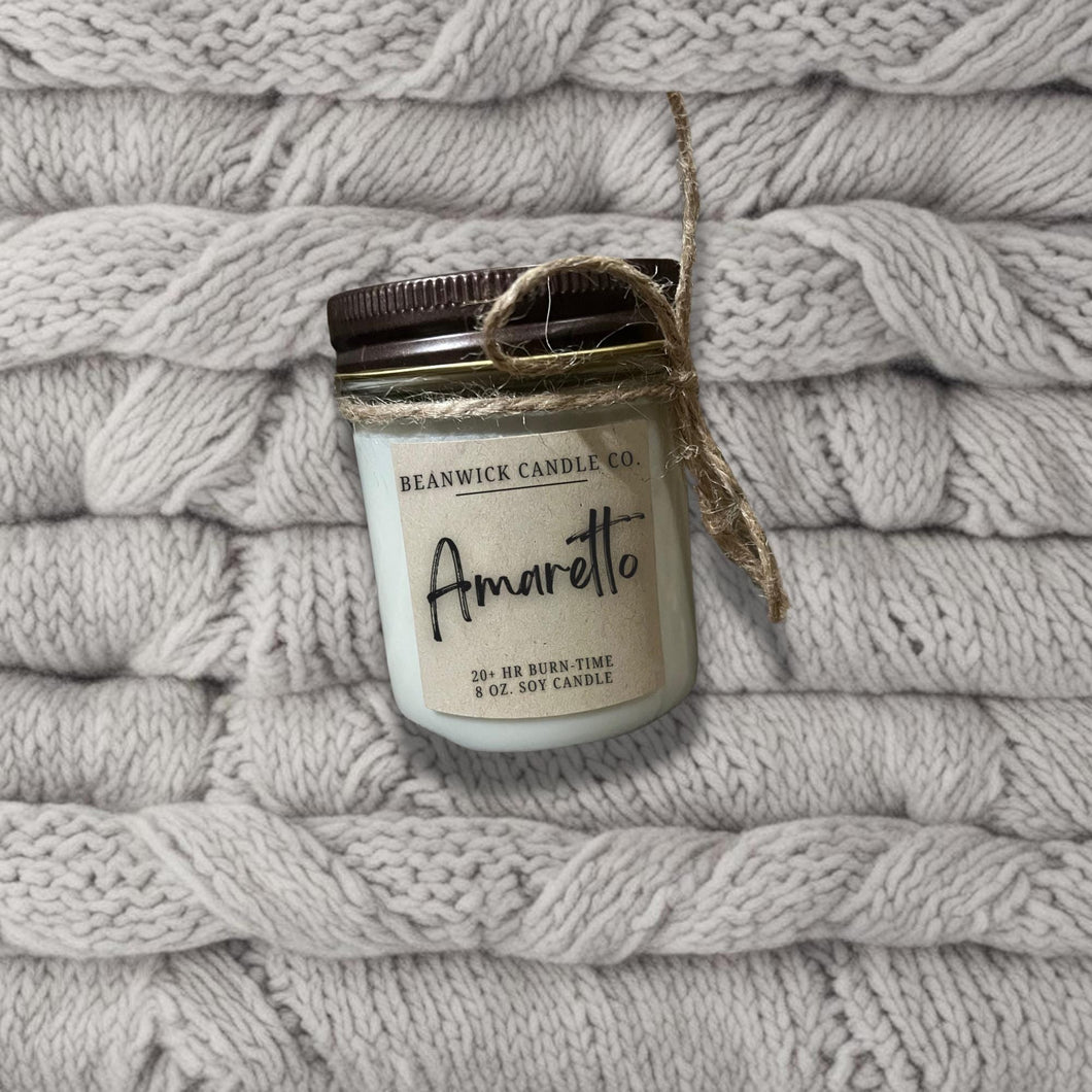 a jar of candle sitting on top of a pile of blankets