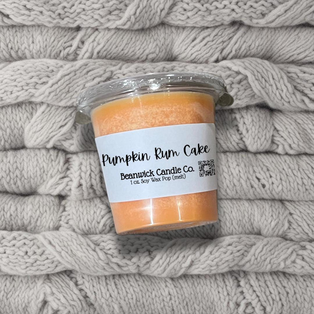 a jar of pumpkin rum cake sitting on top of a pile of blankets