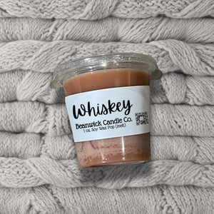 a jar of whiskey sits on a pile of blankets