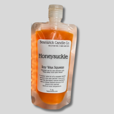 a bottle of honeysuckle soap on a gray background