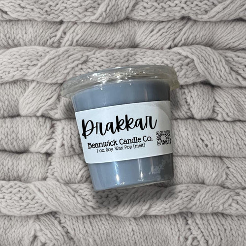 a stack of blankets with a candle on top of it
