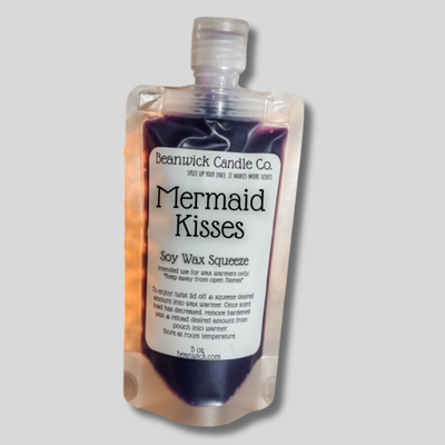 a bottle of mermaid kisses on a gray background