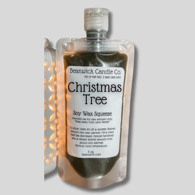 a bottle of christmas tree soap next to a light