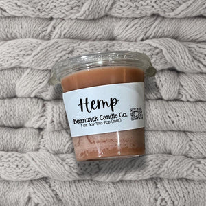 a jar of hemp candle sitting on top of a pile of blankets