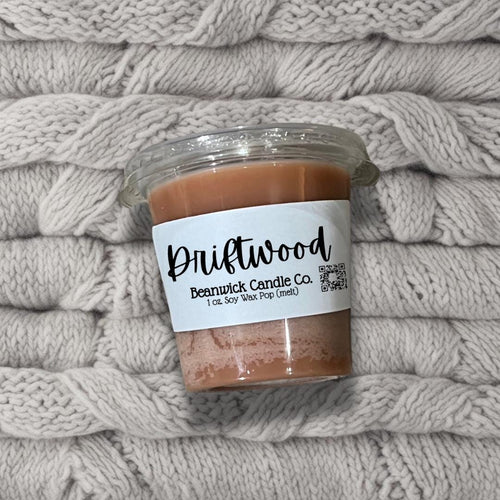 a jar of peanut butter sitting on top of a pile of blankets
