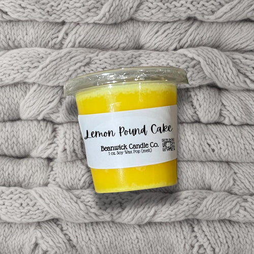 a jar of lemon pound cake sitting on top of a pile of blankets