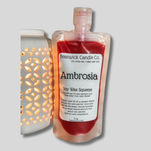 Load image into Gallery viewer, a bottle of ambrosia sitting next to a lamp