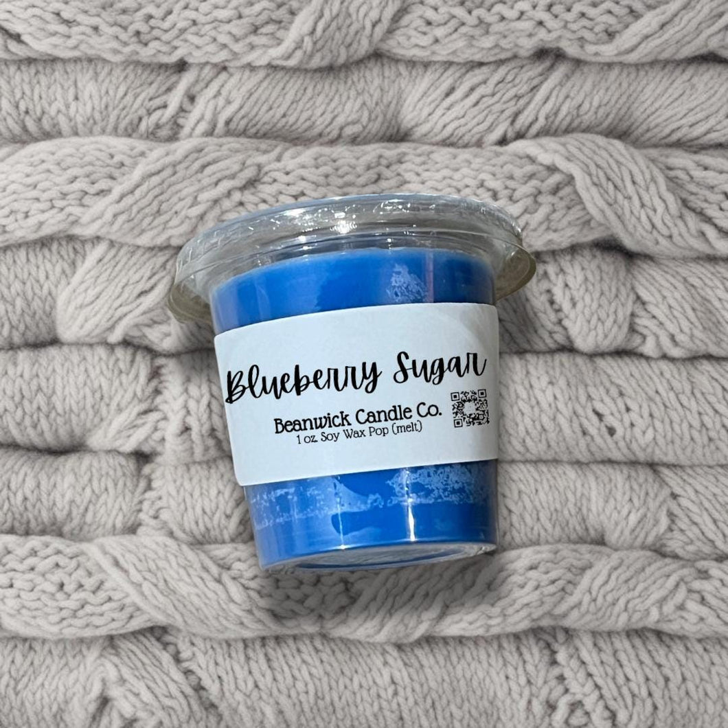 a blue candle sitting on top of a pile of blankets