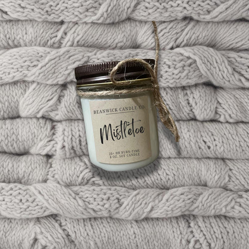 a jar of mistole sitting on top of a pile of blankets