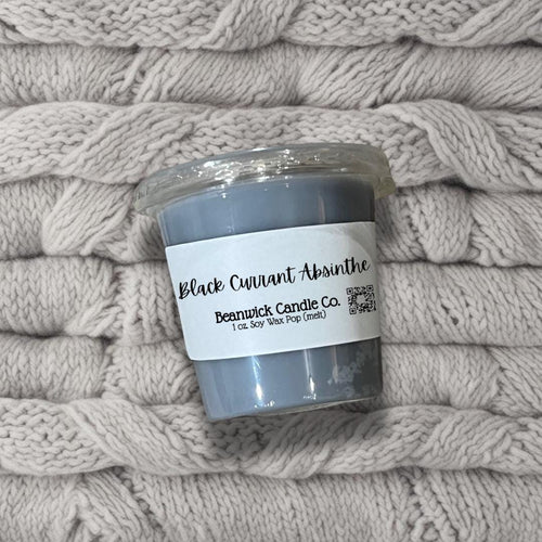 a pile of blankets with a candle on top of it