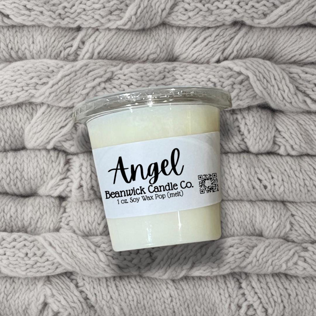 a jar of candle sitting on top of a pile of blankets