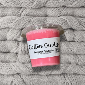 a cup of cotton candy sitting on top of a pile of blankets