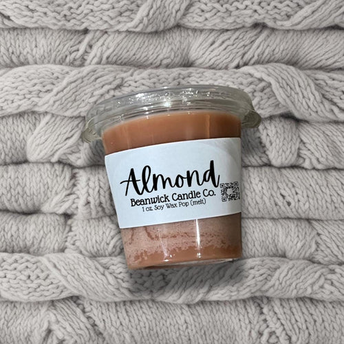 a jar of almond butter sitting on top of a pile of blankets