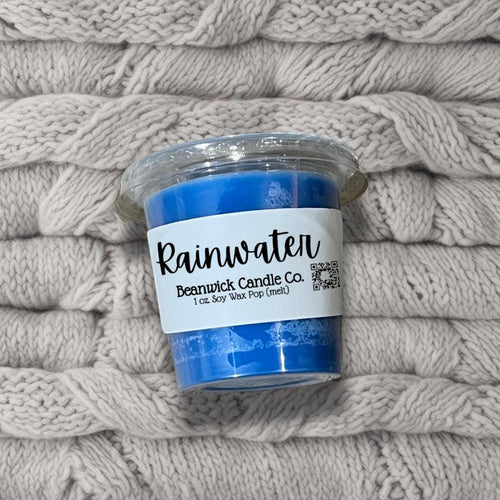 a blue candle sitting on top of a pile of blankets