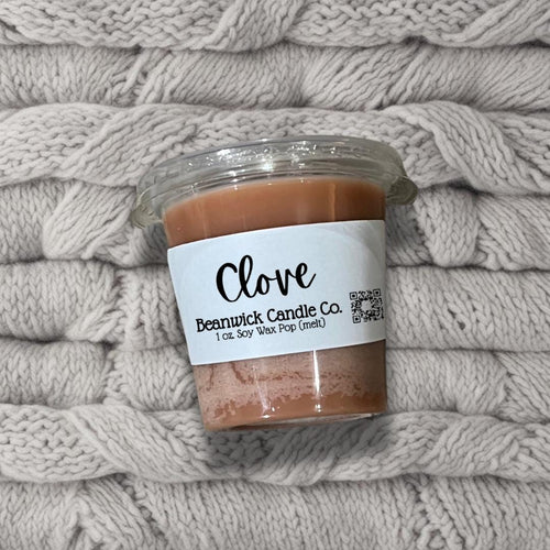 a jar of clove sits on a pile of blankets