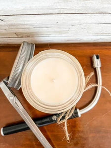 a pair of scissors and a jar of wax on a table