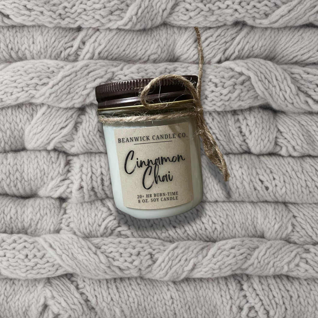 a jar of cinnamon clove sitting on top of a pile of blankets