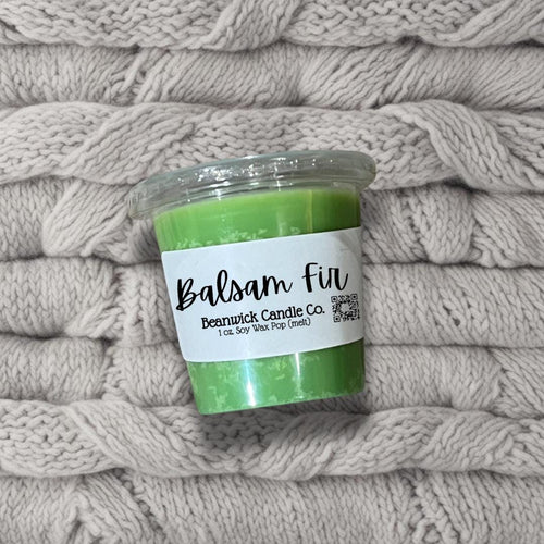 a jar of balsam fun sitting on top of a pile of blankets