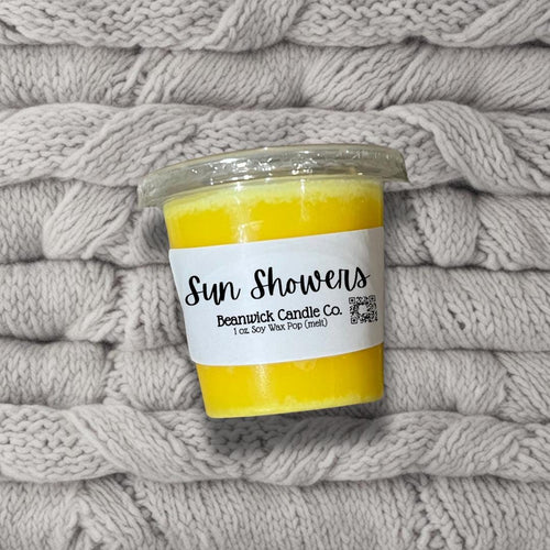 a jar of sunflowers sits on a pile of blankets