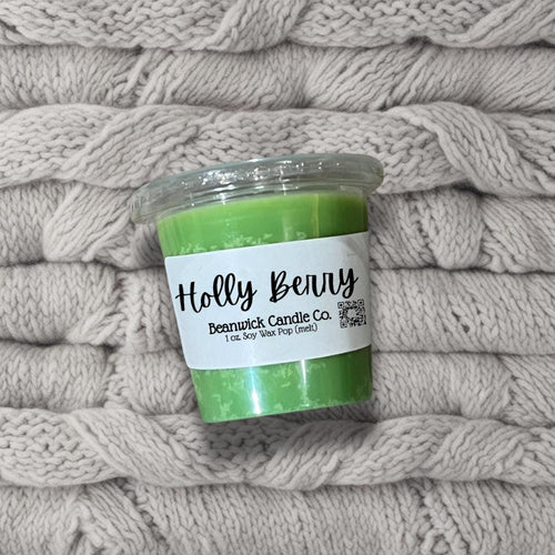a cup of green liquid sitting on top of a pile of blankets
