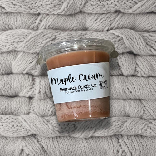 a jar of maple cream sitting on top of a pile of blankets