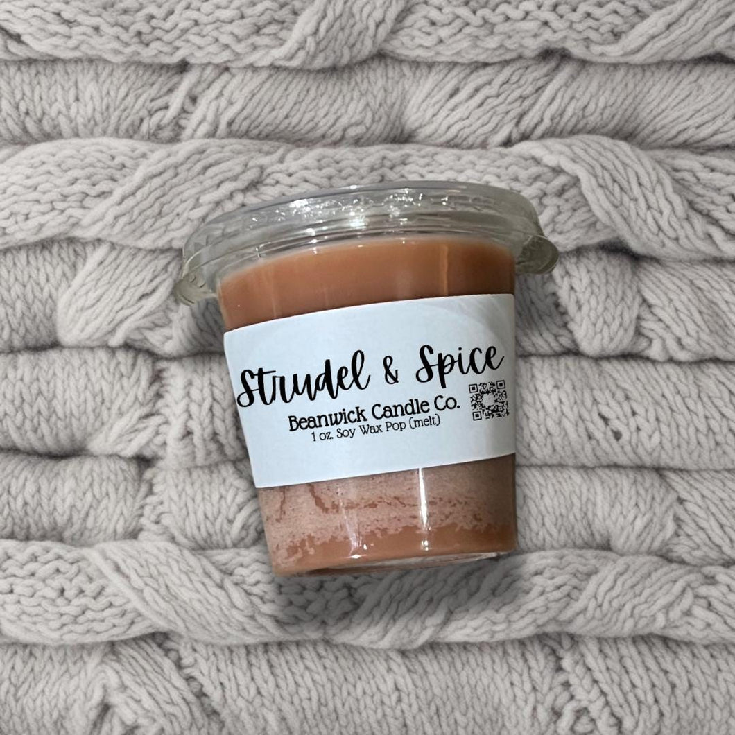 a jar of brown stuff sitting on top of a pile of blankets